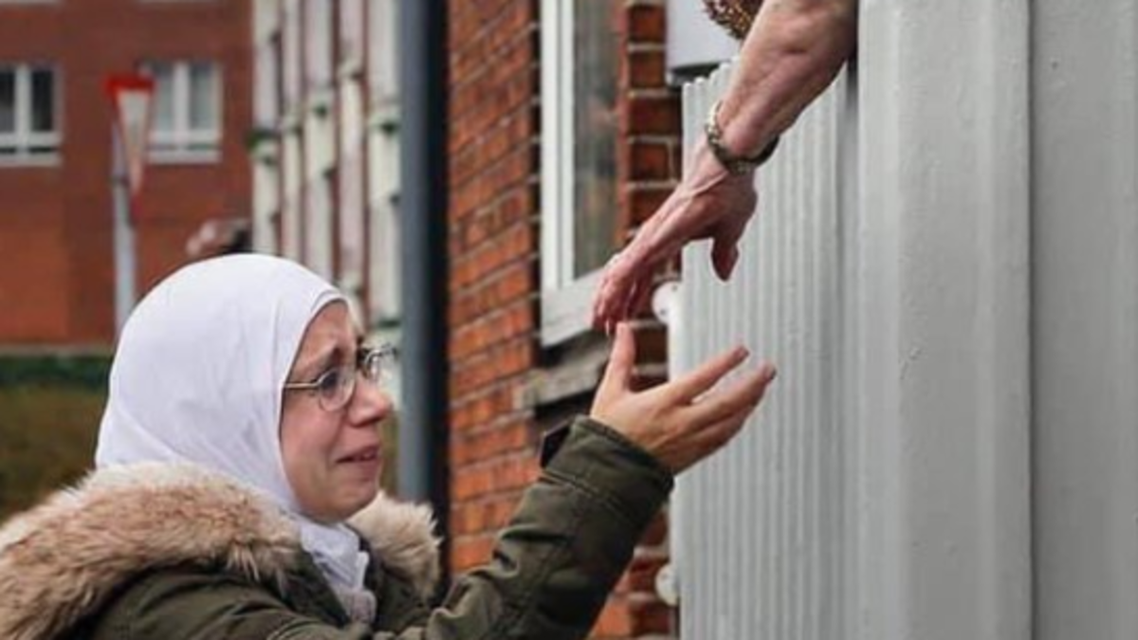 صورة تفطر القلب.. لاجئة سورية تبكي مادة يدها لجارتها

