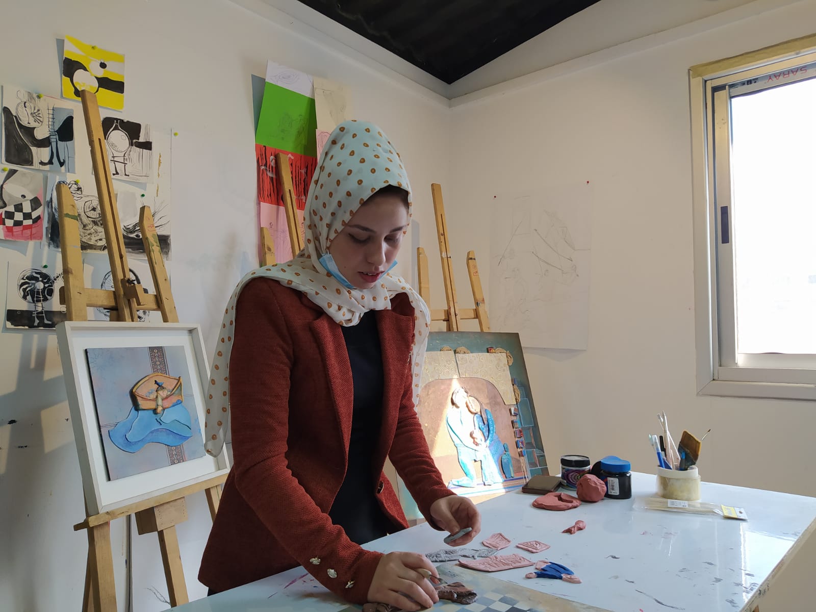 صور| فنانة من غزة ترسم لوحات لدعم المكفوفين
